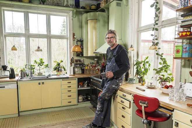 Kunden Lars lutar sig mot en bänk i sitt kök